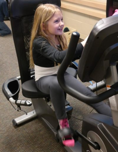 Young female using Exerbike GS interactive pedal game system